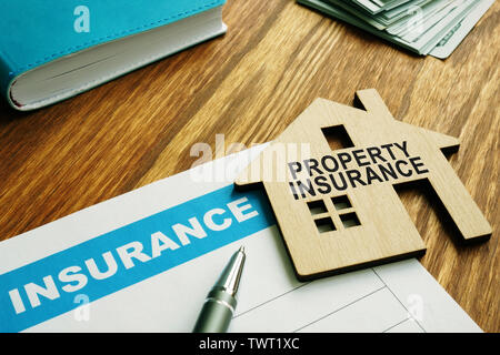 Timbre d'assurance des biens sur un modèle d'accueil en bois. Banque D'Images