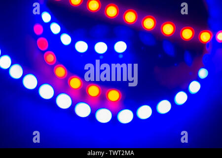 Néon bleu rouge des guirlandes de lumières bokeh et réflexions. Arrière-plan de fête de 80 couleurs. Banque D'Images