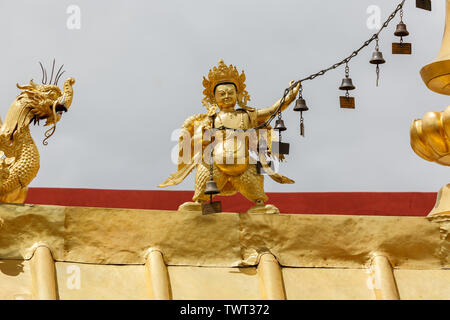 Statue tenant une chaîne avec des cloches sur haut de Temple Jokhang. Les cloches peuvent représenter la voix de la lumière céleste de l'enseignement de Bouddha. / TIbet Lhassa Banque D'Images