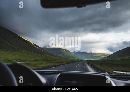 Vue du coucher de soleil nuageux spectaculaire de 1 route principale en Islande par fenêtre de voiture. Et Wanderlust travel concept. Sur le chemin. Banque D'Images
