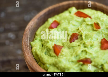 Le guacamole dans le bol sur la table en bois Banque D'Images
