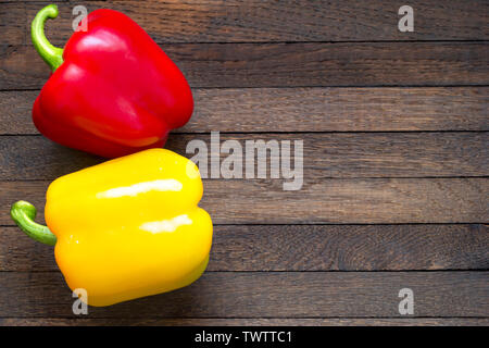 Jaune et Rouge poivrons doux sur la table en bois de chêne avec copie espace. Position gauche. Vue de dessus l'arrière-plan. Close up. Les aliments crus. Nutr sain Banque D'Images