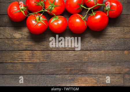 Laver les tomates mûries rouge en haut de l'arrière-plan en bois. Copie de l'espace dans le bas. Les gouttelettes d'eau sur les légumes frais. Vue d'en haut. Close up. L'écrou en bonne santé Banque D'Images