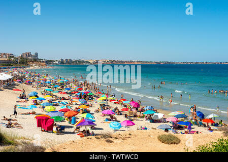 Méditerranée animée de Playa Mil Palmeras, Pilar de la Horadada, Alicante, Espagne, Europe. Parasols colorés, ciel bleu et la mer. Costa Blanca Banque D'Images