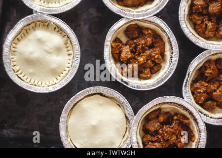 Matières fermé mini-quiches quiches farcies de viande et de champignons, sur un fond sombre. Vue de dessus. Banque D'Images