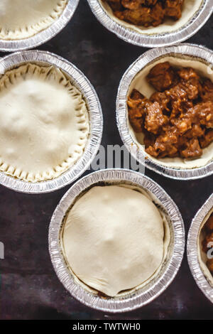 Matières fermé mini-quiches quiches farcies de viande et de champignons, sur un fond sombre. Vue de dessus. Banque D'Images