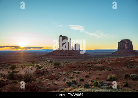 Monument Valley au lever du soleil. Navajo Tribal Park dans la frontière Arizona-Utah USA. Lever de soleil derrière les rochers rouges, le fond de ciel clair Banque D'Images