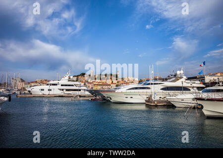 Des yachts de luxe dans le port de la ville de Cannes en France, vieille ville en arrière-plan. Banque D'Images