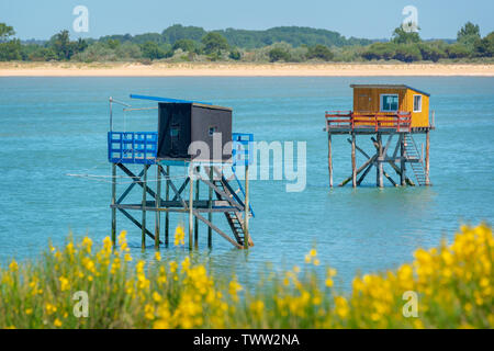 En bois coloré et typique des cabanes de pêche sur pilotis dans l'océan Atlantique près de La Rochelle, France