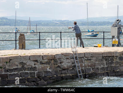 Un homme pêche en mer dans le port, et Ross Cromarty Cromarty, Ecosse. Banque D'Images