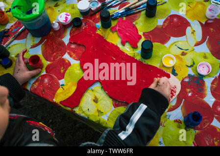 La Russie, de la ville de Yaroslavl - 4 mai, 2019:baby girl s'appuie sur la planche de bois. L'enfant tient le pinceau. Autour il y a les peintures et les bidons d'eau. L Banque D'Images