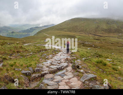 Les marcheurs de la montée dans le raide, mais bien le chemin balisé jusqu'au sommet du Ben Nevis, dans les montagnes de l'Ecosse Royaume-uni sur une journée nuageuse généralement Banque D'Images