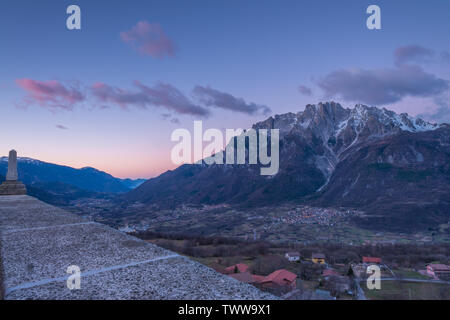 Le lever du soleil sur la ville de Cimbergo en Val Camonica, Italie. Les nuages roses sur les montagnes, les nuages colorés à l'aube dans la vallée. Banque D'Images