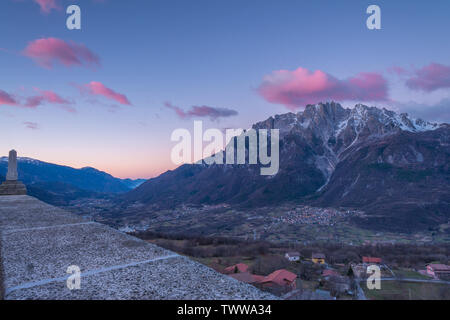 Le lever du soleil sur la ville de Cimbergo en Val Camonica, Italie. Les nuages roses sur les montagnes, les nuages colorés à l'aube dans la vallée. Banque D'Images