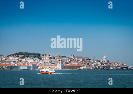 Un ferry traditionnel (Cacilheiro) traversant le Tage avec l'horizon de Lisbonne sur l'arrière-plan. Banque D'Images