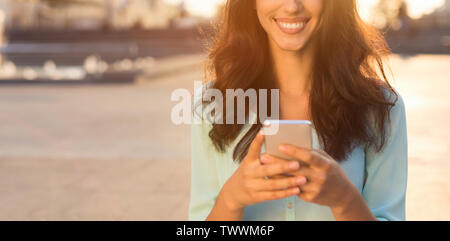 Woman texting on smartphone, marcher dans la rue Banque D'Images