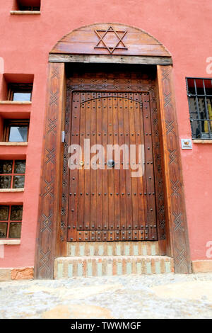 La porte en bois d'une maison espagnole à Grenade, en Espagne, avec une étoile de David sculpté au-dessus de lui ; symboles juifs en Espagne. Banque D'Images