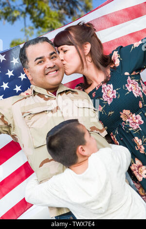 Soldat des Forces armées hispaniques mâles célébrant son retour Holding American Flag. Banque D'Images