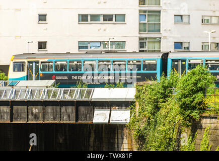 CARDIFF, WALES - Juin 2019 : train de banlieue en livrée provisoire du transport pour le pays de Galles traversant un pont dans le centre-ville de Cardiff Banque D'Images