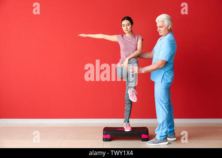 Travailler avec un physiothérapeute mature Young Asian Woman in clinic Banque D'Images