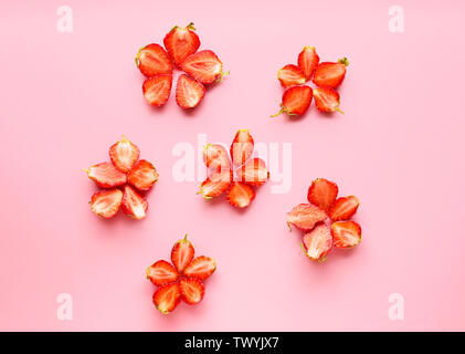 Fleurs faites de fruits rouges sur un fond de couleur fraise Banque D'Images