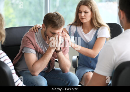 Sad young man at group therapy session Banque D'Images