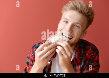 Man eating tasty taco sur un fond de couleur Banque D'Images