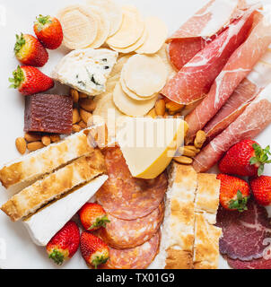 Passage libre d'un plateau d'antipasto avec un mélange de viandes froides, fraises, fromages, des craquelins et du pain Banque D'Images