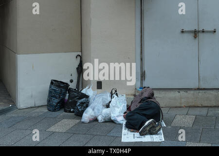 Un homme sans abri dormant dans la rue à Jimbocho, Tokyo, Japon. Banque D'Images