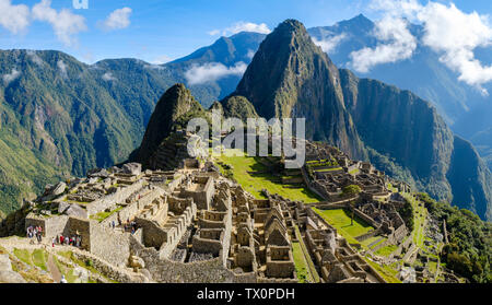 Tôt le matin, vue panoramique sur le Machu Picchu au Pérou, Huayna Picchu, la Vallée Sacrée des Incas. Les touristes visitant les ruines à la première lumière au lever du soleil. Banque D'Images