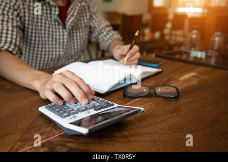 Main man calculatrice pour calculer la taxe à l'office.concept Banque D'Images