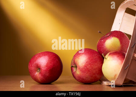 Les pommes biologiques dans le panier sur fond jaune Banque D'Images