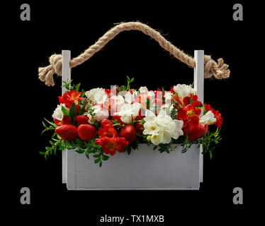 Boîte en bois blanc rempli de roses blanches et rouges et de fraise mûre, isolé sur fond blanc Banque D'Images