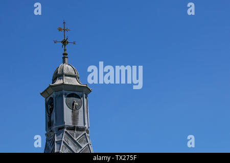 Girouette sur le haut d'un immeuble tour de l'horloge contre un ciel bleu clair Banque D'Images