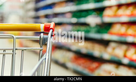 Panier en supermarché. Cadre de chariot de supermarché en face. Dans épicerie étagères floue et chariot. L'espace pour copier du texte ou dessin. Banque D'Images