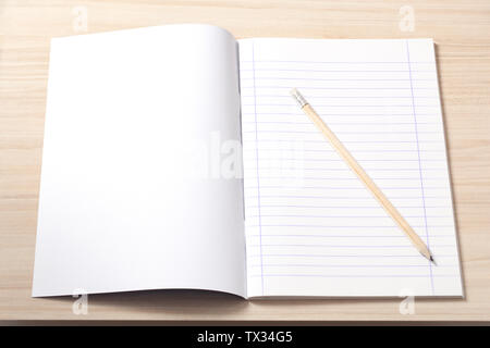 Ordinateur portable ouvert avec des feuilles vierges et un crayon sur un bureau, lieu de travail. Banque D'Images