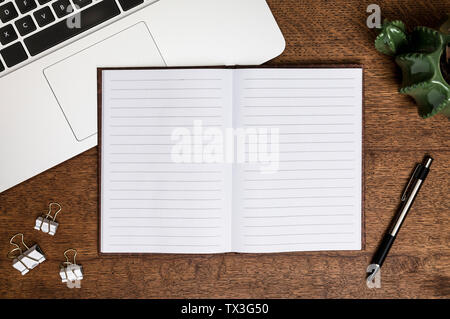 Vue de dessus en blanc, bordée carnet et un stylo à l'ordinateur portable Banque D'Images