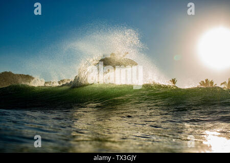 Surfer des vagues d'océan derrière l'air accrocheur au lever du soleil, Sayulita, Nayarit, Mexique Banque D'Images