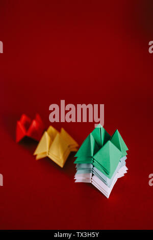 Origami diseuses multicolores sur fond rouge Banque D'Images