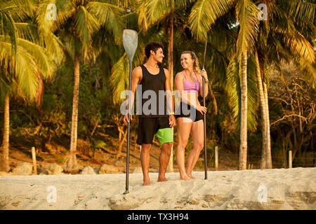 Jeune couple à la rame sur sunny, tropical beach Banque D'Images