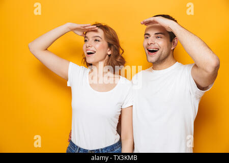 Portrait of a young couple isolés sur fond jaune, à loin Banque D'Images