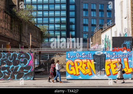 Une vue sur la rue de Shoreditch High Street à Londres avec des graffitis sur les panneaux d'architecture avec le message sur l'année 1 Grenfell et toujours pas de justice. Banque D'Images