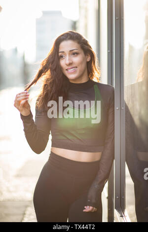 Portrait of smiling young woman sportive dans la ville Banque D'Images