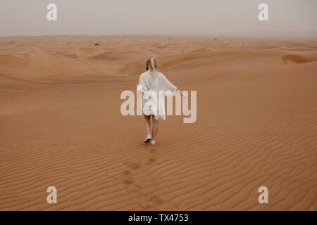 Emirats arabes unis, dubaï, Lahbab Désert, woman walking in desert landscape Banque D'Images