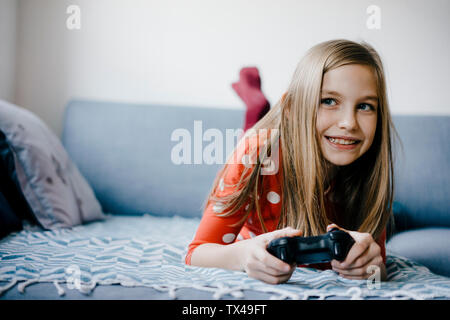 Happy girl playing video game at home Banque D'Images