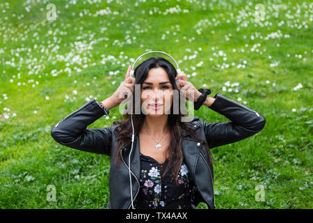 Portrait de jeune femme avec un casque blanc, portant veste en cuir noire Banque D'Images