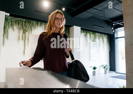 Jeune femme entrant spa avec carte à puce Banque D'Images