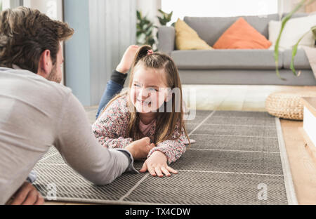Jeune homme et petite fille étendue sur le sol, bras de fer Banque D'Images