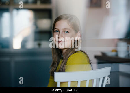 Portrait of a Girl sitting on chair at home Banque D'Images