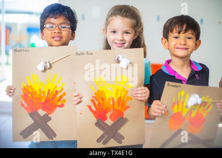 Portrait of smiling children présenter les images d'incendie de la maternelle Banque D'Images